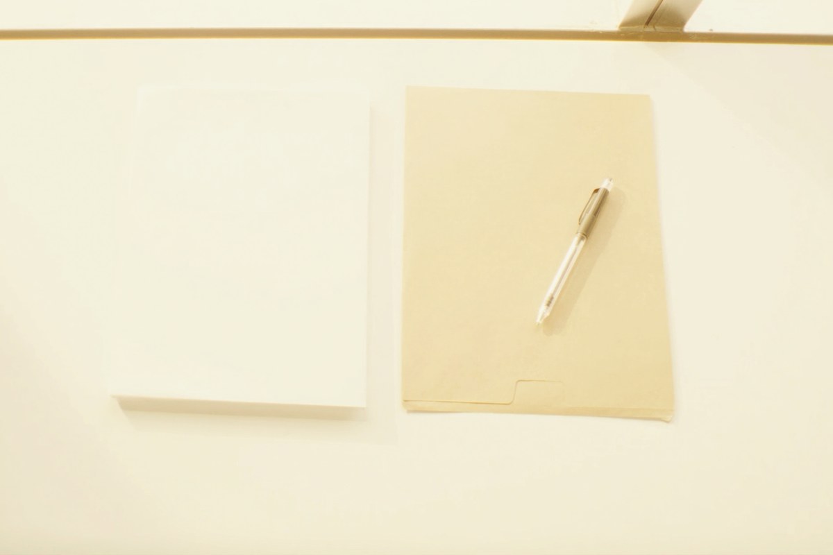 明るいオフィスの机に置かれた書類とペン。相続税の調査は申告の翌年から翌々年の秋が多い